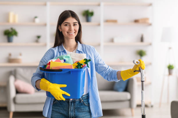 Women Cleaner holding cleaning tools with smile